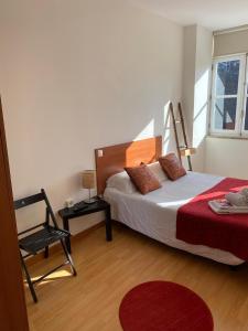 波尔图Formosa Oporto Apartments Group的卧室配有床、椅子和窗户。