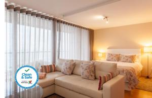 波尔图Bartolomeu Beach Apartments的客厅配有沙发和1张床
