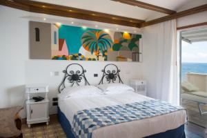 马萨鲁布朗斯Taverna Del Capitano的卧室配有一张床,墙上挂有绘画作品