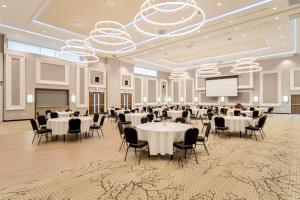 布兰特福德TownePlace Suites by Marriott Brantford and Conference Centre的宴会厅配有桌椅和屏幕