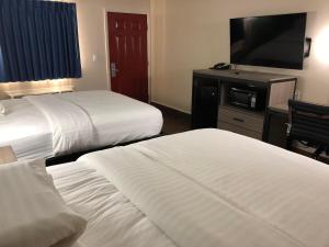 霍顿旅行者沃顿套房汽车旅馆的酒店客房设有两张床和一台平面电视。