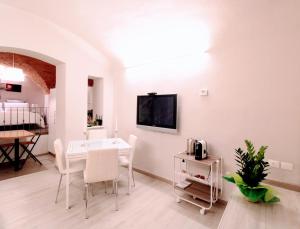 锡耶纳Suite al Duomo的客厅配有白色的桌子和椅子