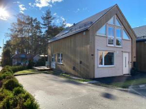SøgneÅrostunet 4K Nær Kristiansand dyrepark的车道上带太阳能屋顶的房子