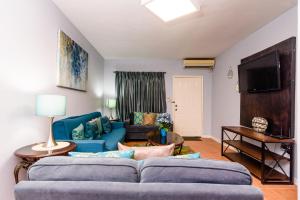 安东尼奥港添竹酒店的客厅配有蓝色的沙发和电视