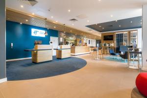 博德明Holiday Inn Express - Bodmin - Victoria Junction, an IHG Hotel的大堂设有蓝色的墙壁和桌椅