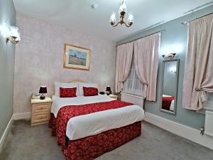 罗切斯特The Gordon House Hotel的一间卧室配有一张大床和镜子