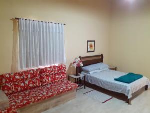 佩尼多Casa Chalé em Penedo的一间带两张床和一张沙发的卧室