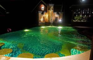 琅勃拉邦Chateau Orientale Resort的游泳池在晚上设有喷泉