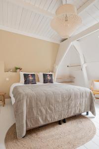莱茵河畔阿尔芬Boutique Hotel - de Stadsherberg Alphen的白色卧室配有一张带地毯的大床