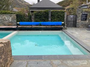 卡德罗纳Cardrona Valley Studio (17)的庭院内带蓝色靠垫的游泳池