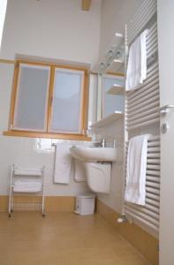 托尔博莱Windshouse的一间带水槽和卫生间的浴室以及窗户。