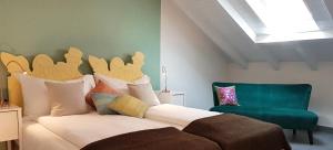 洛迦诺莫塔酒店的一间卧室配有一张床和一把绿色椅子