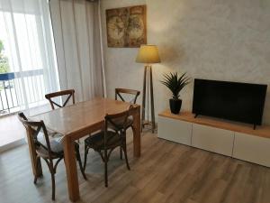 勒格罗-迪鲁瓦GRAU DU ROI T2 calme, accès plage + parking的客厅配有木桌和电视。