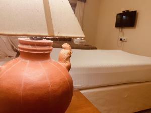 阿伯来Pinnacle Holiday Homes的一间卧室配有一张床和一个带灯的花瓶
