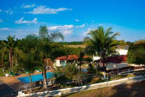 圣代佩德罗Hotel Paraíso Dos Alpes的一个带游泳池和棕榈树的度假村