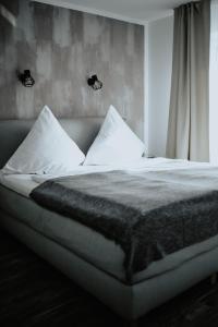 汉诺威Excellentas Apartments Hannover的卧室内的一张带白色床单和枕头的床