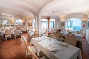 滨海波利尼亚诺萨拉森尼科沃酒店的一间设有白色桌椅的用餐室