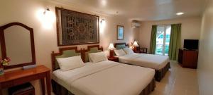 马六甲Hotel Johan的酒店客房,设有两张床和镜子