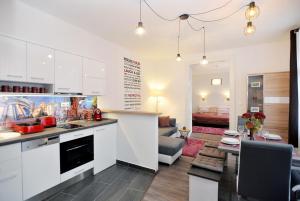埃格尔Nobilis Apartman Eger的一间带白色橱柜的厨房和一间客厅