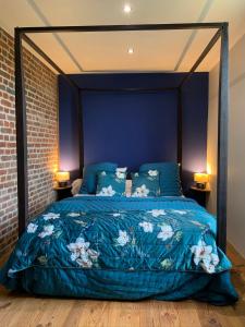 莫伯日Gîtes du Grand Bois的一间卧室配有一张带蓝色棉被的床