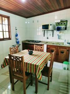 蒂拉登特斯Aconchego de Regina的厨房配有桌椅和炉灶。