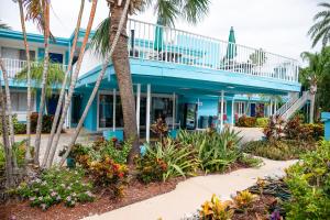 圣徒皮特海滩湾畔及滨海旅馆的一座种植了棕榈树和鲜花的蓝色建筑