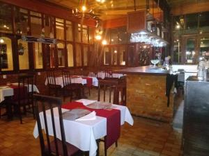 贝伦hotel le Massilia的一间带桌椅的餐厅和一间酒吧