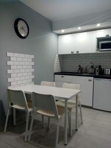 布勒伊-切尔维尼亚Alfastudio的厨房配有桌椅和墙上的时钟