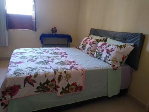 伦索伊斯Hospedaria Casa de Adriana的一张带花卉床罩和枕头的床