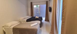 弗洛里亚诺波利斯Hi Adventure的客房设有两张床、一台电视和一扇窗户。