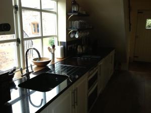 布里奇诺斯Duken Courtyard Cottage的厨房配有柜台、水槽和窗户