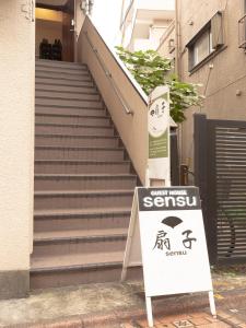 东京Guesthouse Sensu的楼梯前的标志,带有起始标志