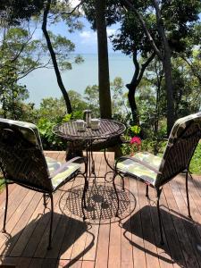 MialloGunnadoo Holiday Hut with Ocean Views and Jacuzzi的露台甲板上的桌椅