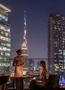 迪拜迪拜国际金融中心四季酒店的坐在屋顶桌子上的男人和女人