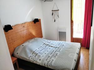皮伊圣万桑Appartement 4/6 personnes Puy Saint Vincent的一间卧室配有一张带木制床头板的床