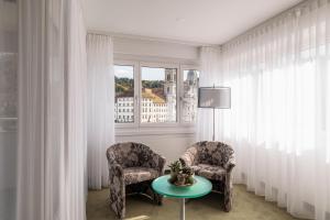艾因西德伦德莱科尼肯酒店的带窗户的客房内配有两把椅子和一张桌子