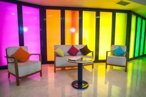 萨拉戈萨萨拉戈萨拉米罗1号宜必思尚品酒店的色彩缤纷的墙壁里,有两把椅子和一张桌子
