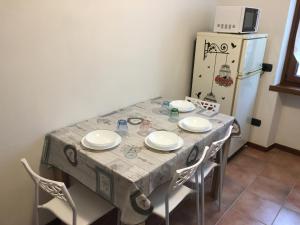 RonchiApartment Annarosa的餐桌、四把椅子和冰箱