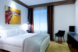 巴勒莫普林奇比迪维拉弗兰卡酒店的一间酒店客房,配有一张白色的床和一张书桌