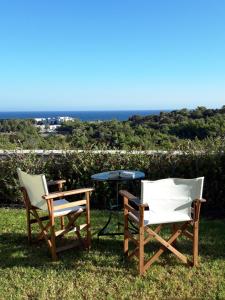 吉奥塔略Petroto Villas的草地上的两把椅子和一张桌子