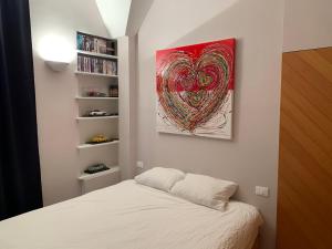 蒙特卡罗Very Central suite apartment with 1bedroom next to the underground train station Monaco and 6min from casino place的卧室配有一张床,墙上挂有绘画作品