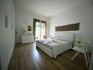 莱切Villa "Le Giare"的白色的卧室设有床和窗户