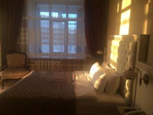 托木斯克Old Town的一间卧室设有一张床、一个窗口和一把椅子
