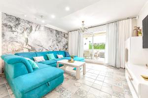 阿德耶Luxury Townhouse Oasis Fanabe (3 bedrooms)的客厅配有蓝色的沙发和桌子