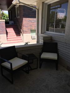 盐湖城8th South Apartments的两把椅子和一扇窗户,位于带楼梯的大楼内