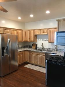 盐湖城8th South Apartments的厨房配有木制橱柜和不锈钢冰箱。