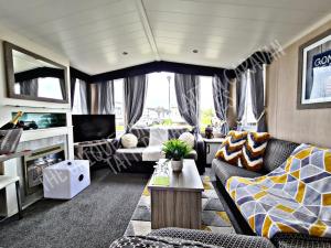 塔特舍尔Tattershall Luxury Hot Tub Caravan的带沙发和电视的客厅