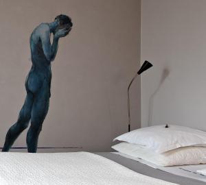 布鲁日布鲁日之夜住宿加早餐旅馆的一张躺在床边的男人雕像