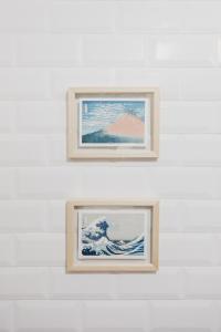 克鲁什港Jaca Hostel Porto da Cruz的两幅波浪画,画在白色的墙上
