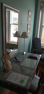 莫法特Kirkview House的客厅配有带台灯的桌子